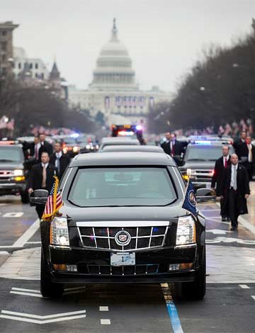 A motorcade in Washington D.C. with the capitol behind the cars.