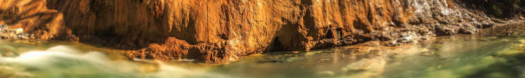 Stream by a big rock in the woods