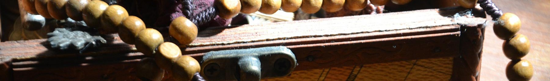 An old box with wooden rosary beads spilling out of it. 