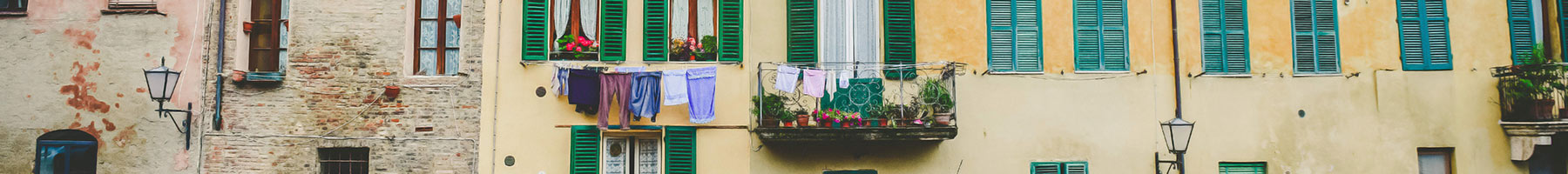 laundry hanging outside an apartment building window and flowers in a window box
