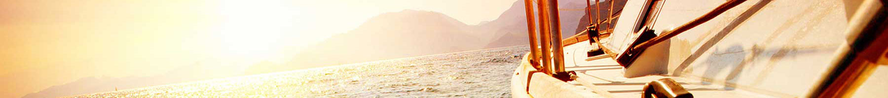 photo of a sunset over the water with the deck of a boat nearby