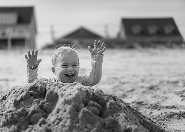 a boy playing in a sandpile