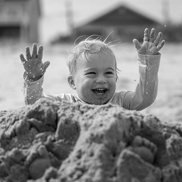 a boy playing in a sandpile