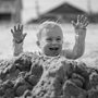 a boy playing in a sandpile