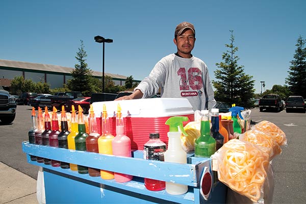 Llevando consigo el carrito de raspado, este oaxaqueño inmigró ilegalmente a EEUU para poder ganar el pan.