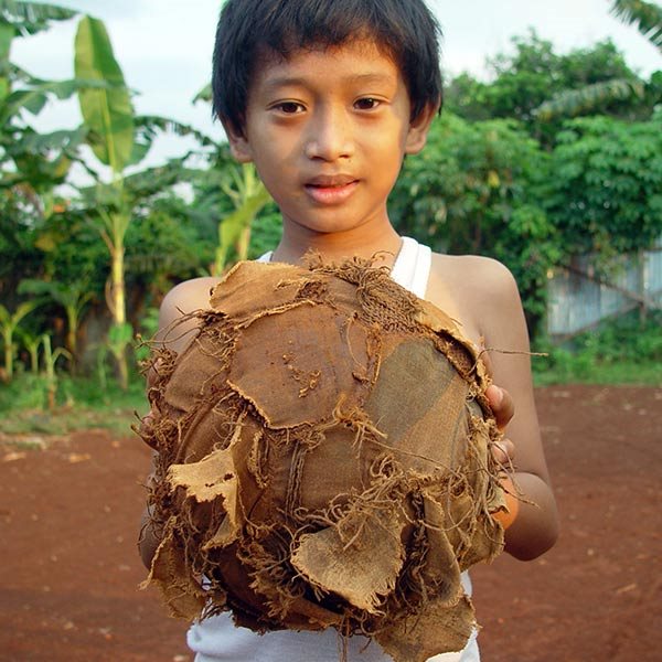 boy holding makeshift soccer ball
