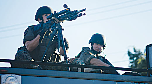 a police sharpshooter in position at a protest in Ferguson, Missouri Photographs by Jamelle Bouie / Wikimedia