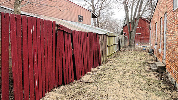 red wooden fence between two buildings