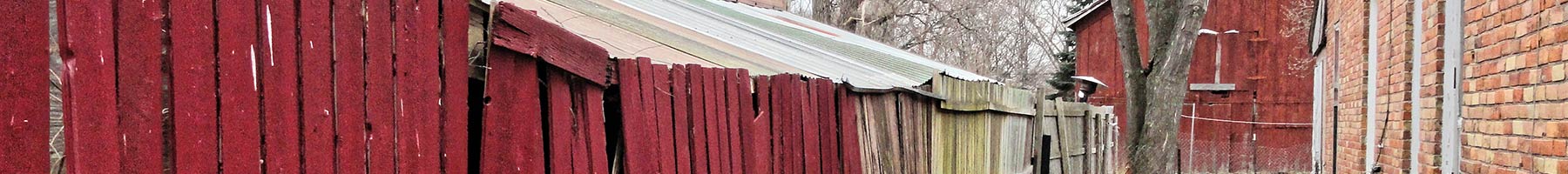 red wooden fence between two buildings