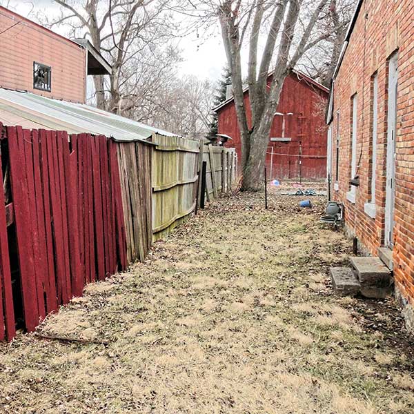 red wooden fence between two buildings