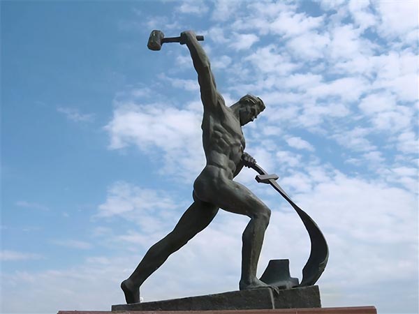 sculpture of a man beating a sword with a hammer
