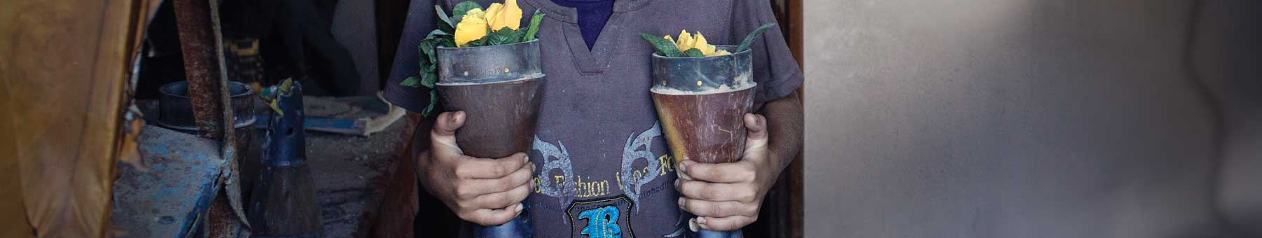 child holding vases made of bomb shells