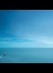tiny lighthouse by huge sea and sky
