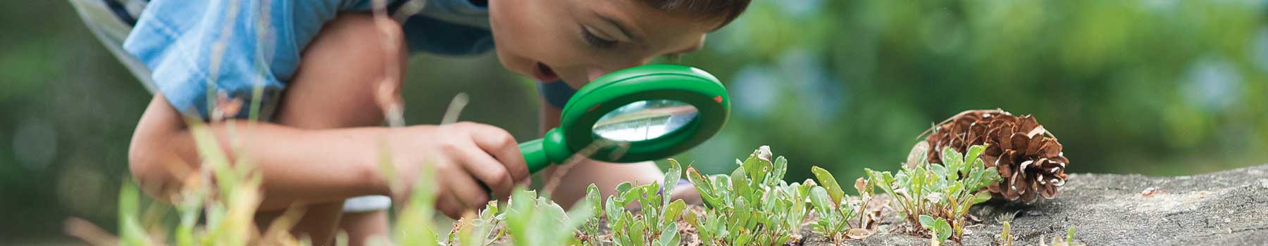 boy looking thru magnifying glass