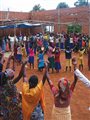 Villagers, both Tutsi and Hutu, gather to celebrate at the building site of a community center
