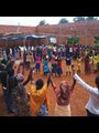 Villagers, both Tutsi and Hutu, gather to celebrate at the building site of a community center