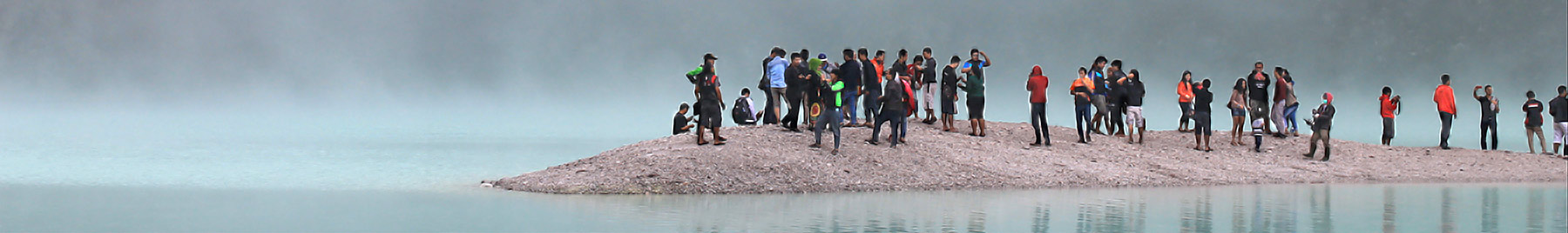 a group of people on a sandbar surrounded by ocean