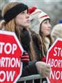 A line of women holding signs at a pro-life rally