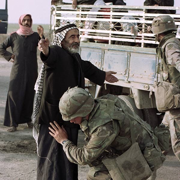 A US soldier frisking an elderly Iraqi man