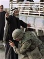 A US soldier frisking an elderly Iraqi man