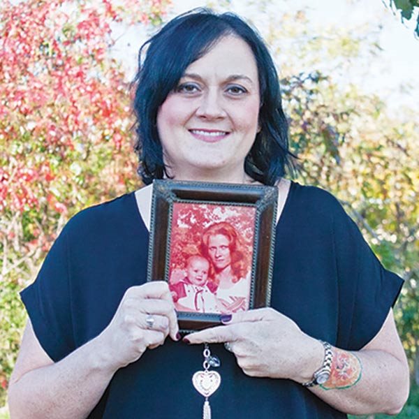 Daughter of a murder victim holds a picture of her mother