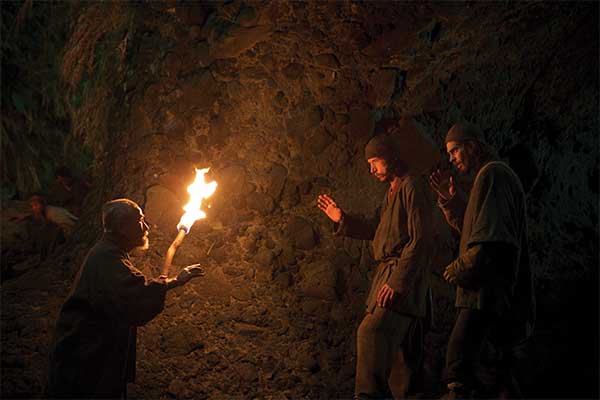 Scene from the film Silence: After wading ashore by night, missionary priests Garrpe and Rodrigues are welcomed by Ichizo.