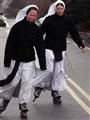 two nuns rollerblading down a street
