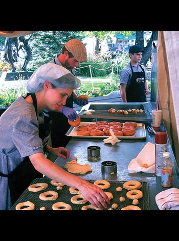 a Mennonite woman makes donuts in a tent