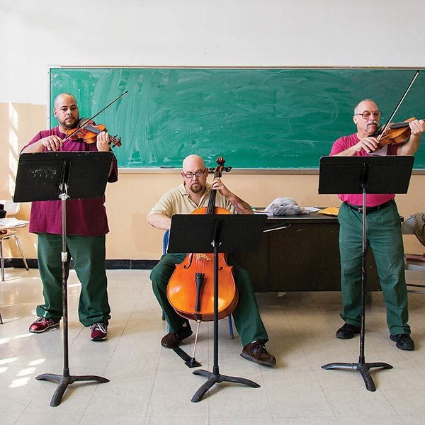 inmates playing stringed instruments