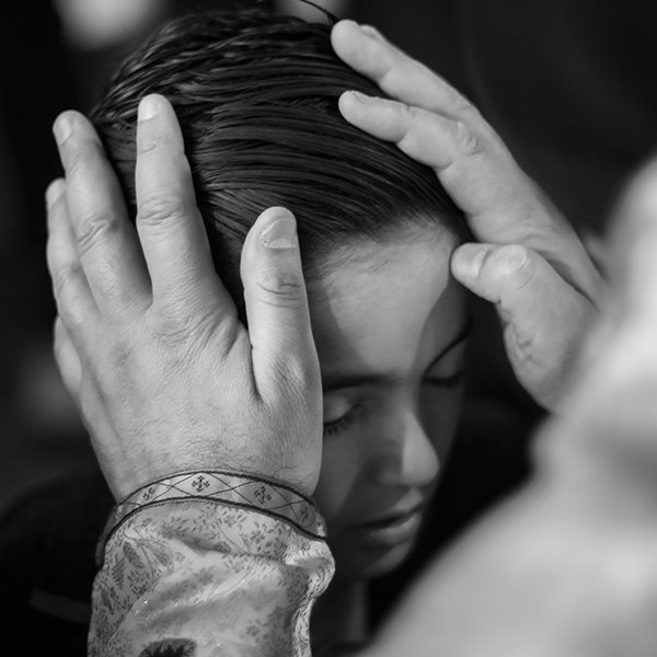 a priest blessing a young boy