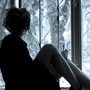 Girl in high heels sitting on a windowsill and looking out. 