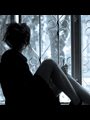Girl in high heels sitting on a windowsill and looking out.