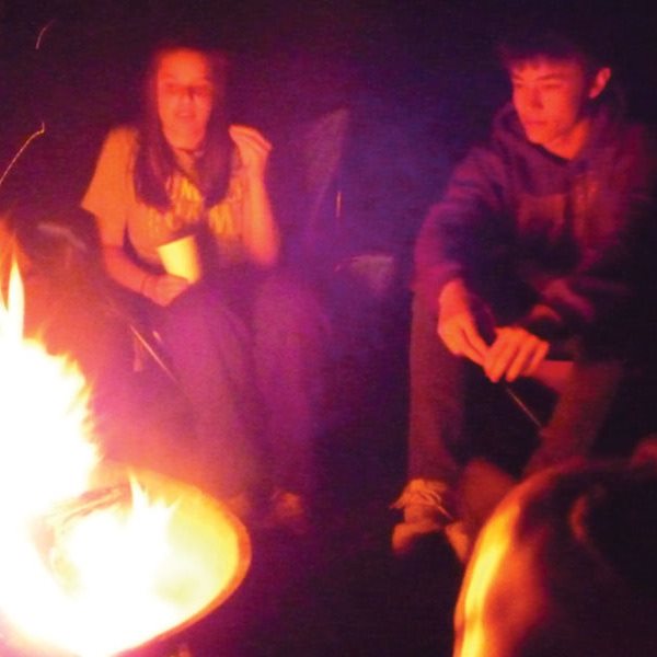 teenagers around a campfire in the dark