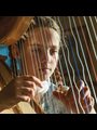 Marlys plays the harp her father made
