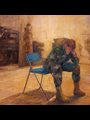 a soldier sitting on a chair with his head in his hands
