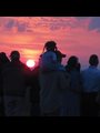 silhouettes of people in front of a sunrise