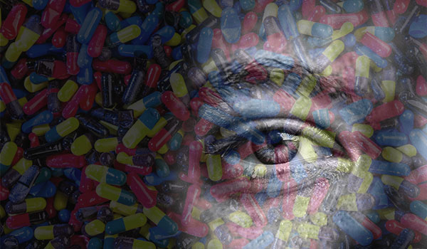 transparent image of an eye over photograph of pills