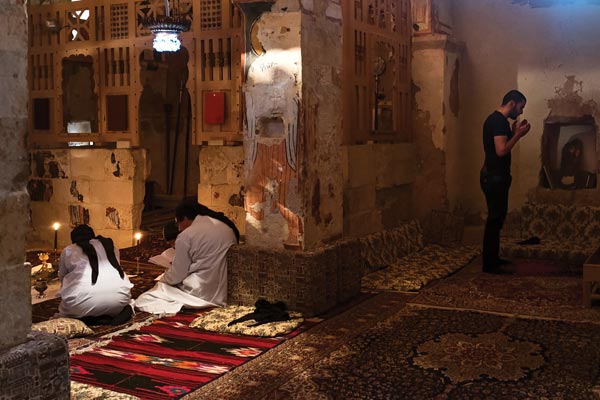 Muslim and Christians praying in a remote church together, each in their own tradition. Photograph by Cécile Massie