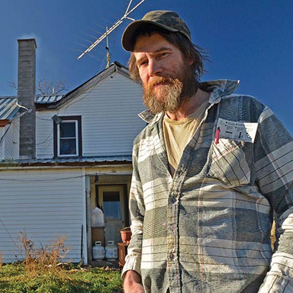 a man standing in front of an old house