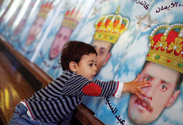 The son of one of the twenty-one Coptic Christians killed by ISIS in 2015 touches the face of his father, Hany. The icons of the martyrs are in a church in El-Aour, Egypt.
