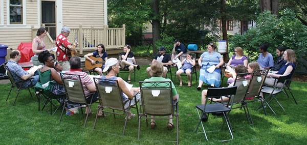 people sitting in a circle of lawn chairs