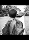 a black and white photograph of a boy looking at a school bus