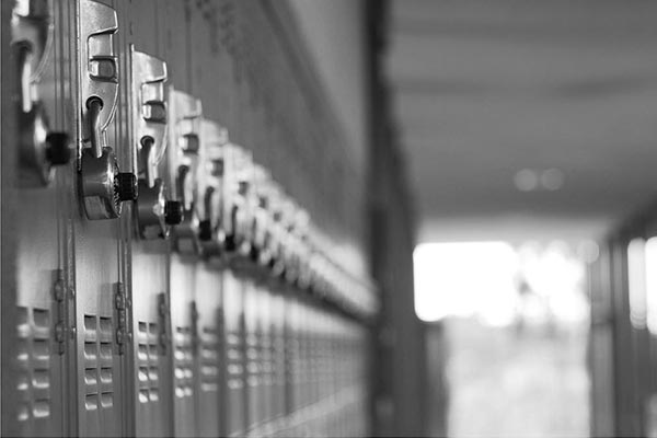 a black and white photograph of metal lockers in a long hallway