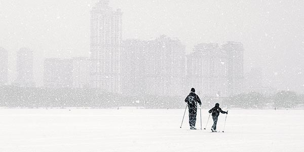 a man and a boy skiing in the snow