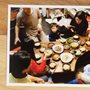 photograph on a wooden table of families eating a Korean meal