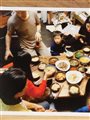 photograph on a wooden table of families eating a Korean meal