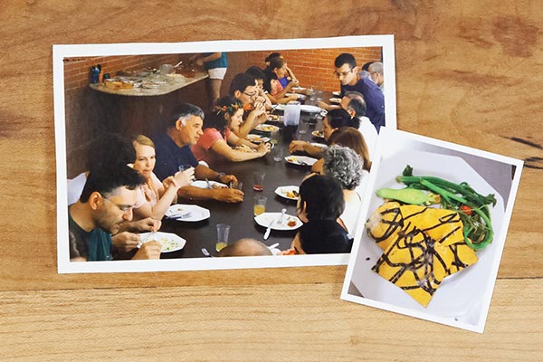two photos on a wooden table, one of people eating together and the other of a beautiful pasta dish