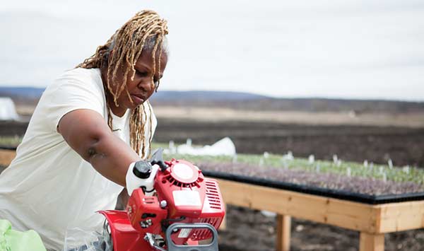 Karen Washington servicing a tiller at Rise & Root Farm in Chester, New York