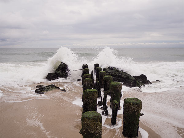 ocean waves breaking on an old wooden pier