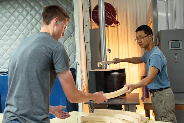 Young men unloading a cart of lacquered wooden blocks